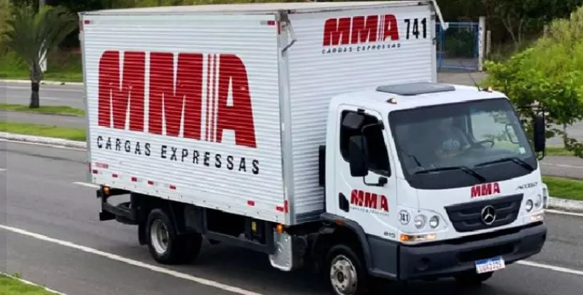 A foto mostra um caminhão baú da MMA Cargas Expressas