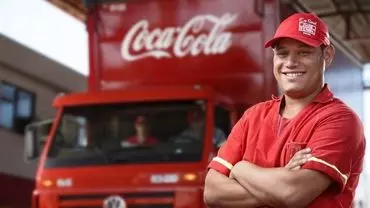 A foto mostra um caminhão e motorista da Solar Coca-Cola