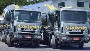 A foto mostra dois caminhões betoneiras da Cortesia Concreto