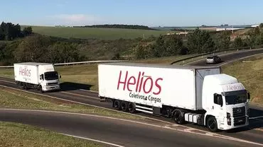 A foto mostra uma carreta e um caminhão da Helios Coletivos e Cargas