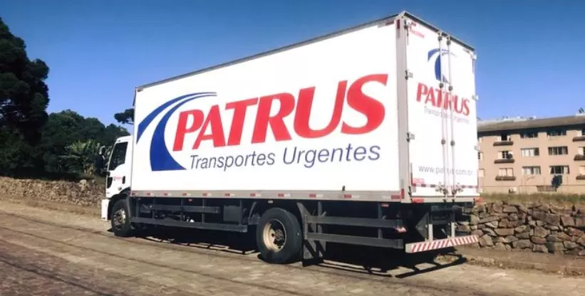 A foto mostra um caminhão Truck da Patrus Transportes